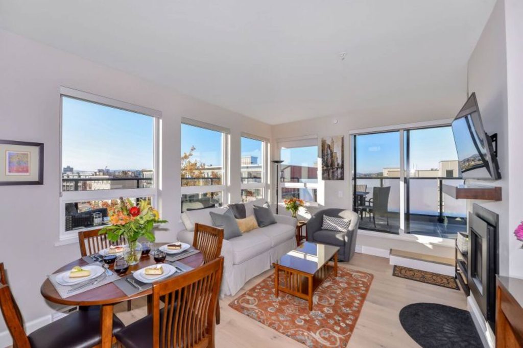 Main Living & Dining with seating for 4. Dedicated work space with a desk and office lamp, gas fireplace and large windows surrounding for a bright and spacious living space!